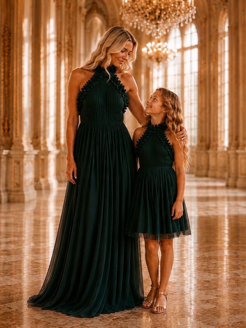 Mother and daughter in matching deep green gowns by Maison Orayat